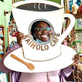 Fellow posing in larger coffee cup poster board with head cut out