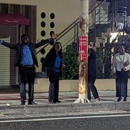 Fellows standing outside at night on the streets of Okinawa